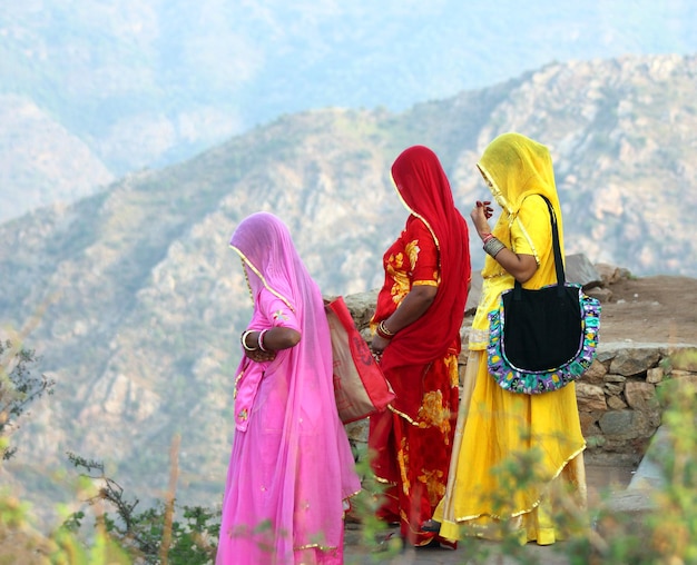 Foto mujeres indias en saris coloridos encima de la colina