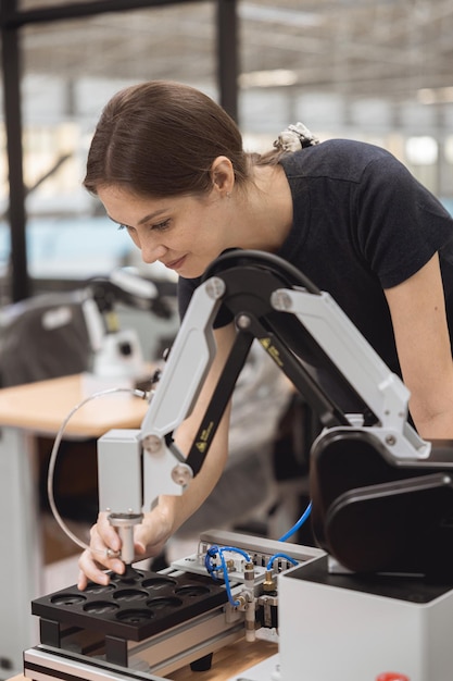 Mujeres ingenieras aprenden educación en el programa de Robótica Industrial con un modelo de simulación de brazo robótico en el aula de laboratorio de ingeniería de la universidad