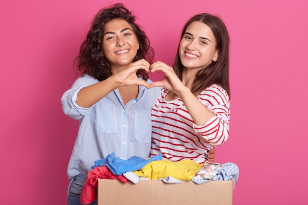 Mujeres jóvenes agradables con ropa casual posando aislado sobre rosa