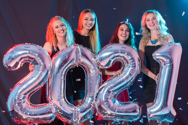 Mujeres jóvenes alegres celebrando la víspera de año nuevo 2021