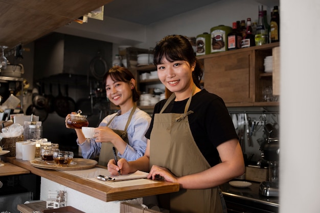 Foto mujeres jóvenes arreglando su pastelería