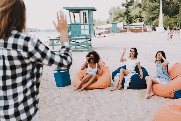 Foto mujeres jóvenes atractivas en bolsas de fiesta en la playa