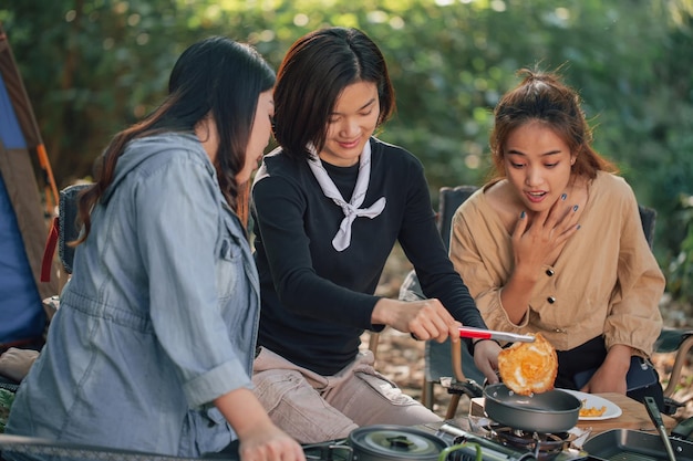 Mujeres jóvenes cocinando huevo frito