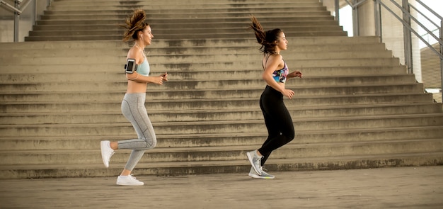 Mujeres jóvenes corriendo en entorno urbano