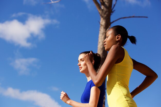 Foto mujeres jóvenes corriendo juntos al aire libre