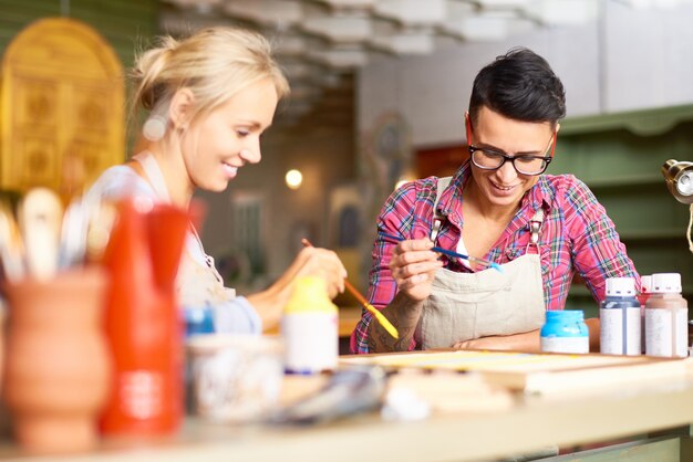 Mujeres jóvenes creativas pintando juntas