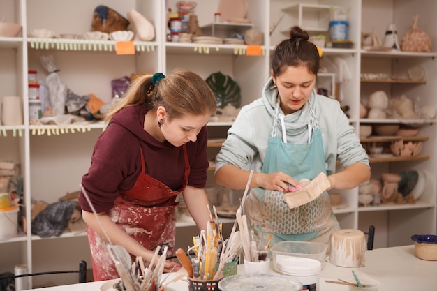 Las mujeres jóvenes disfrutan trabajando con cerámica en el taller de alfarería