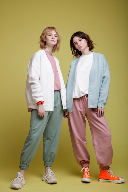 mujeres jóvenes elegantes con traje deportivo blanco, rosa y verde menta sobredimensionado, chaqueta, estilo de caminar