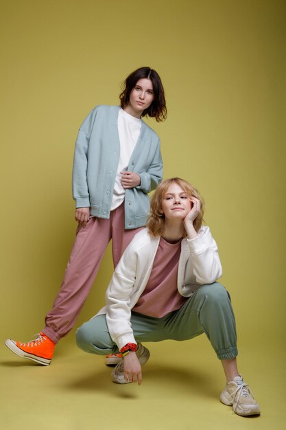 mujeres jóvenes elegantes con traje deportivo blanco, rosa y verde menta sobredimensionado, chaqueta, estilo de caminar