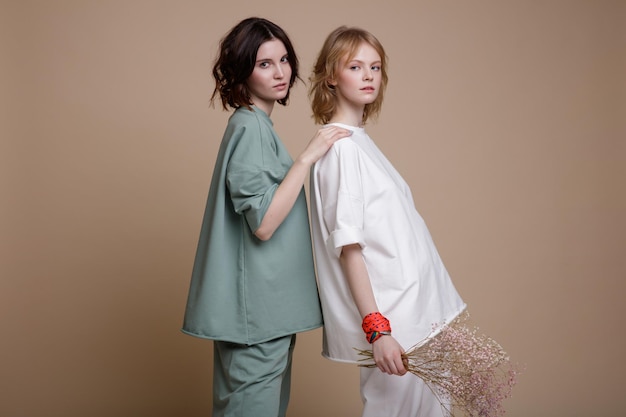 mujeres jóvenes elegantes con traje deportivo de menta blanca y verde, estilo de caminar, posando de gran tamaño en marrón