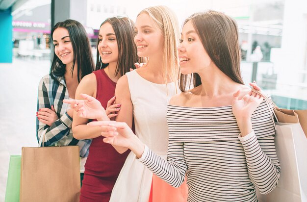 Las mujeres jóvenes están de pie una tras otra y posando