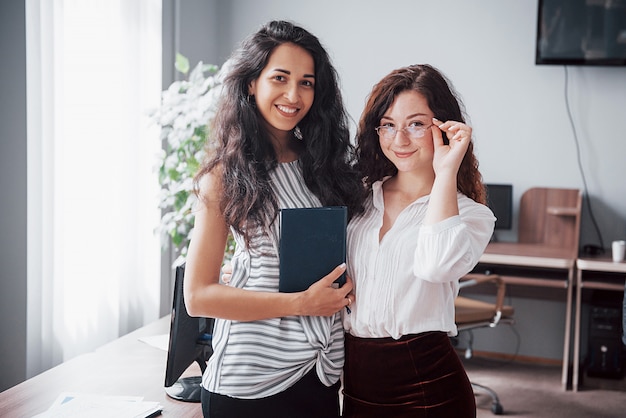 Las mujeres jóvenes están trabajando en la oficina.