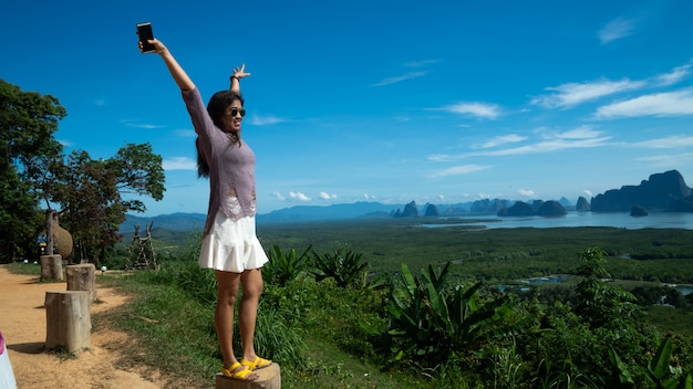 Foto mujeres jóvenes felices disfrutando de vista al valle desde la cima de una montaña