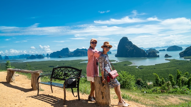 Foto mujeres jóvenes felices disfrutando de vista al valle desde la cima de una montaña