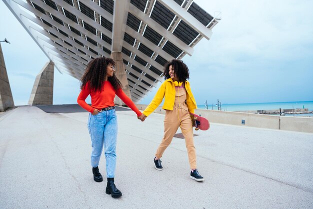 Mujeres jóvenes felices divirtiéndose al aire libre riendo y compartiendo buen humor