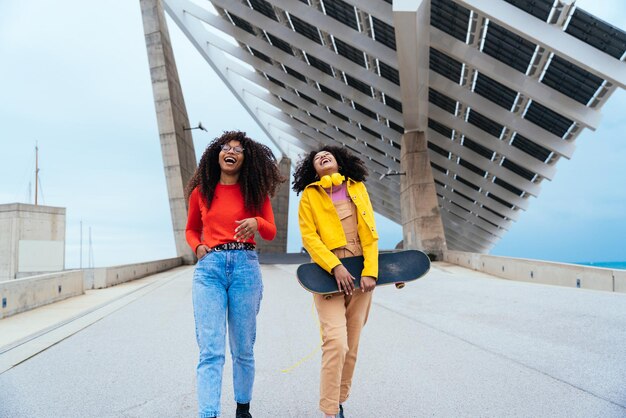 Mujeres jóvenes felices divirtiéndose al aire libre riendo y compartiendo buen humor