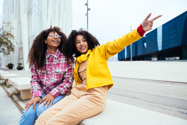 Mujeres jóvenes felices divirtiéndose al aire libre riendo y compartiendo buen humor