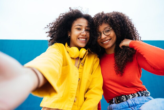 Mujeres jóvenes felices tomando selfies con el teléfono inteligente