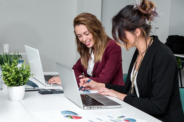 Mujeres jóvenes en laptops