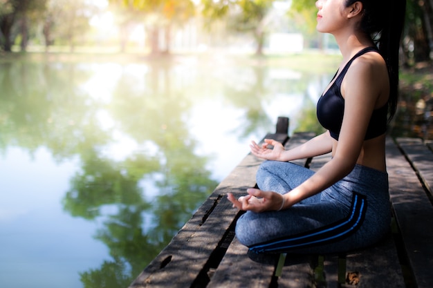 Las mujeres jóvenes meditan mientras hacen yoga en atmósfera pacífica