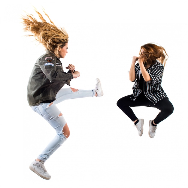 Mujeres jóvenes peleando en el aire