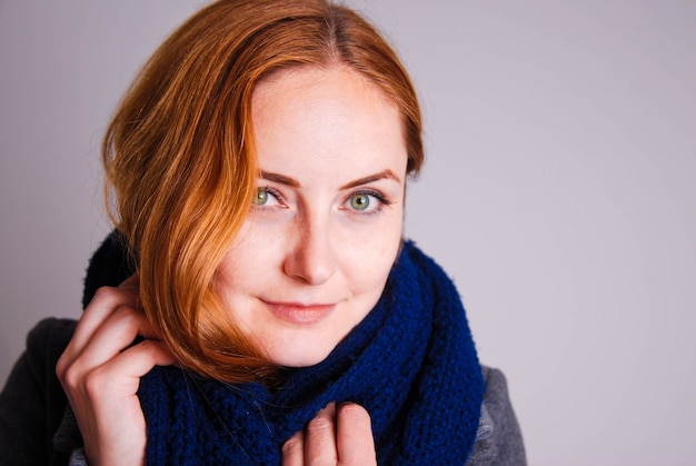 Mujeres jóvenes con pelo rojo y bufanda de punto azul.