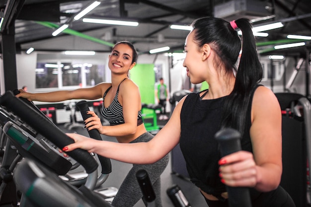 Las mujeres jóvenes positivas y agradables se miran y sonríen.