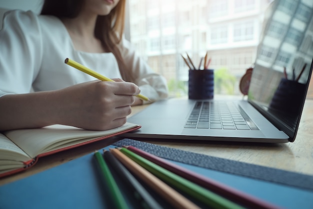 Mujeres jóvenes que trabajan con lápiz de color y cuaderno