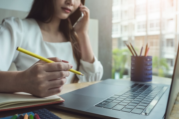 Mujeres jóvenes que trabajan con lápiz de color y cuaderno