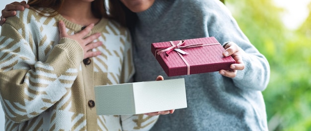 Mujeres jóvenes sorprendidas abriendo una caja de regalo juntas