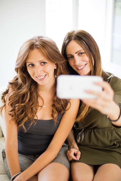 Mujeres jóvenes tomando selfie en la habitación
