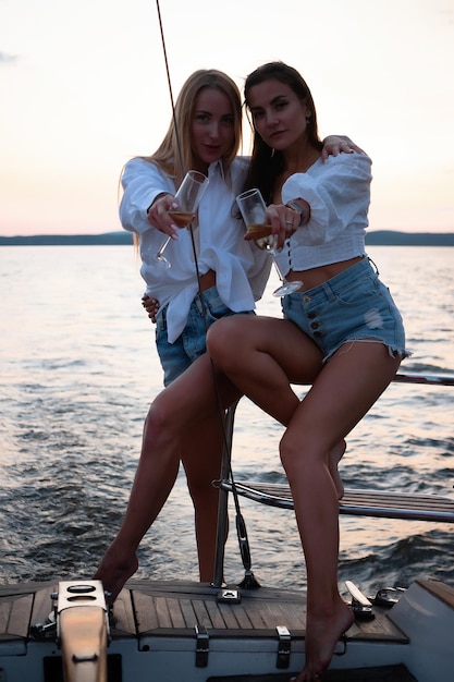 Mujeres jóvenes en yate al atardecer