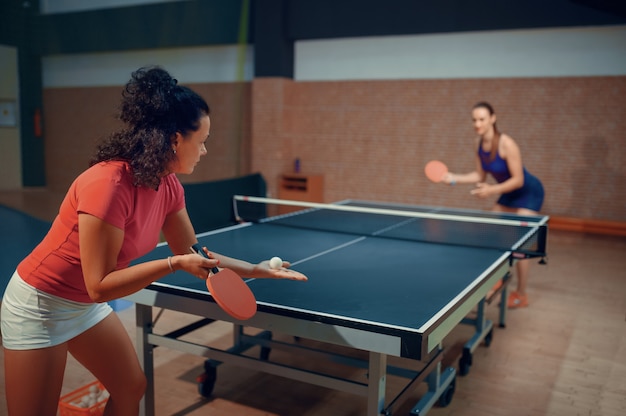 Las mujeres juegan un partido de ping pong, jugadores de tenis de mesa