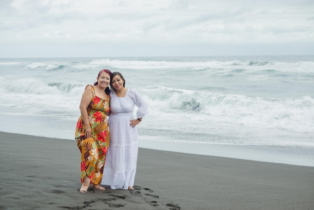 Mujeres, madre e hija disfrutando de un tiempo de calidad en la playa. Océano Pacífico, día nublado.