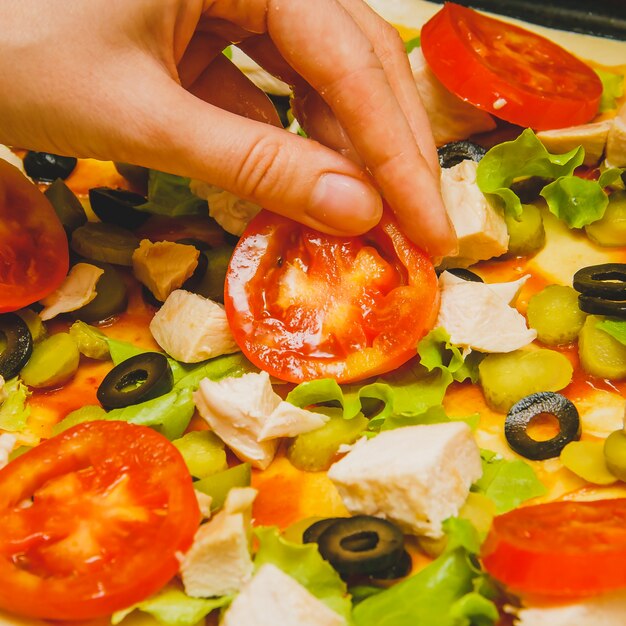 Las mujeres a mano preparan pizza casera.