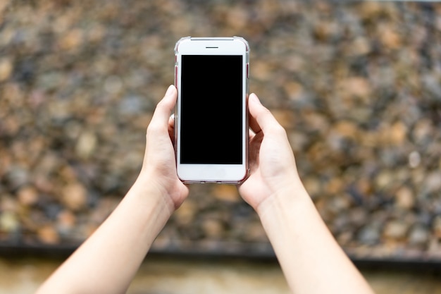 Mujeres mano sosteniendo el teléfono inteligente. concepto de negocio.