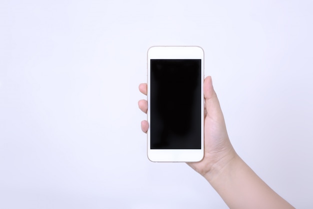 Foto mujeres mano sujetando el teléfono móvil contra el fondo blanco.