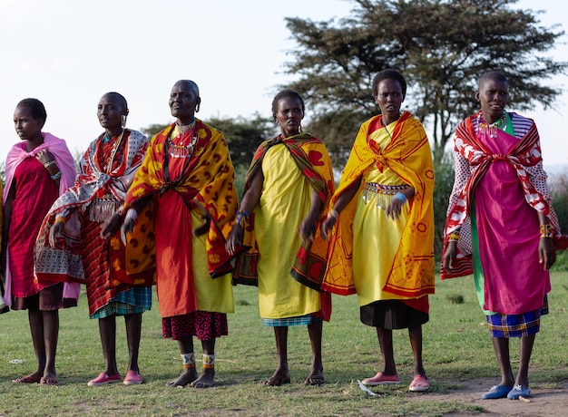 Mujeres masai mara con sus coloridas ropas tradicionales bailando juntas. Masai Mara, Kenia