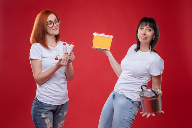 Mujeres con materiales de construcción en pared roja