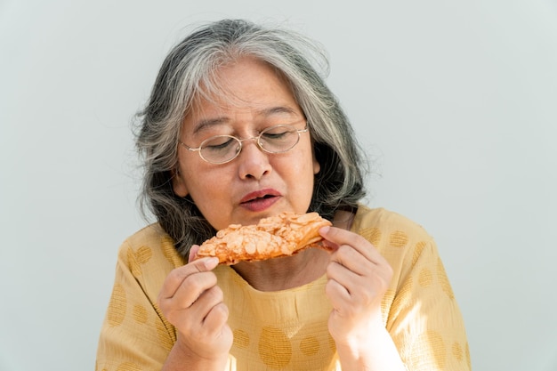 Mujeres mayores asiáticas felices que disfrutan de comer la empanada