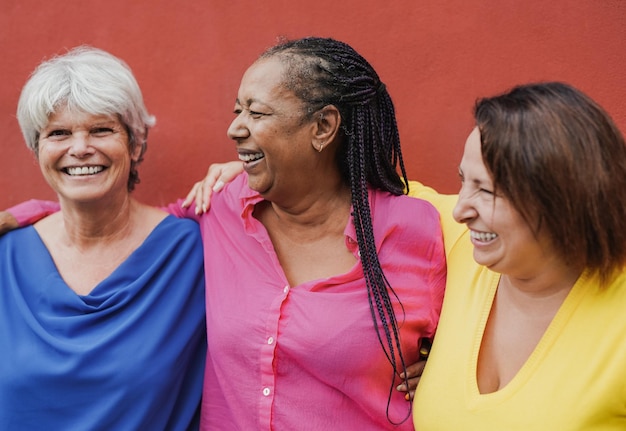 Las mujeres mayores felices disfrutan del día y se abrazan juntas al aire libre