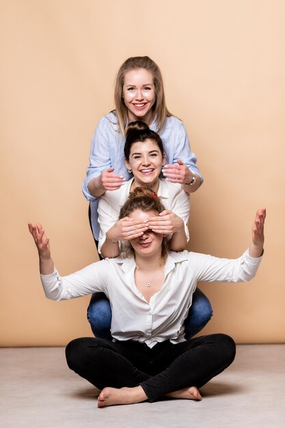 Foto mujeres multiculturales felices y con sobrepeso en sostenes aisladas en beige belleza diversa tres damas multiétnicas envueltas en toallas de baño posando sonriendo a la cámara en fondo beige toma de estudio