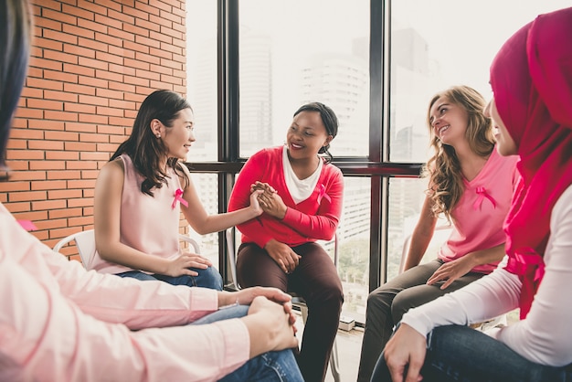 Mujeres multietínicas casuales sentadas en círculo en la reunión.