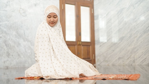 Las mujeres musulmanas asiáticas realizan las oraciones obligatorias en la mezquita