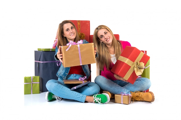 Mujeres de la Navidad que sostienen los regalos sobre el fondo blanco