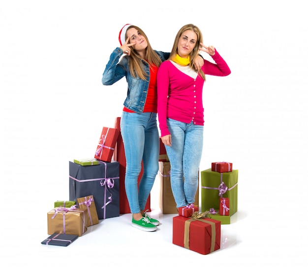 Mujeres de la Navidad que sostienen los regalos sobre el fondo blanco