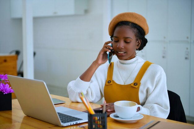 Mujeres de negocios afroamericanas están llamando a teléfonos móviles en la oficina - negros