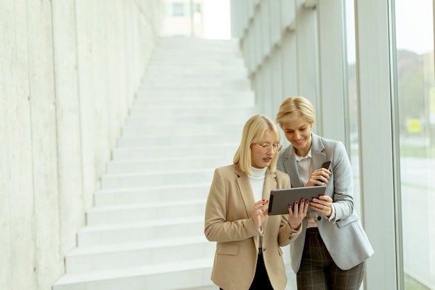 Mujeres de negocios caminando en el pasillo de la oficina