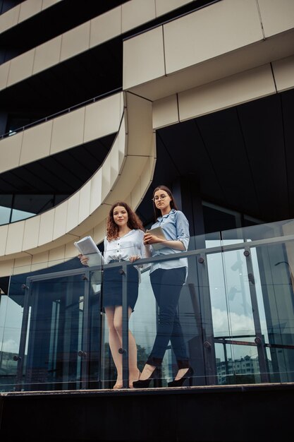 Mujeres de negocios cerca del edificio de oficinas