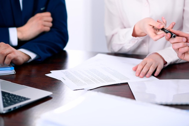 Mujeres de negocios dando un bolígrafo al hombre de negocios para firmar un contrato